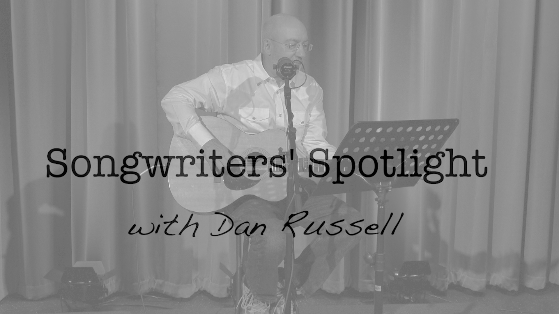 richard dubuc playing the guitar and singing with the words songwriter's spotlight over him